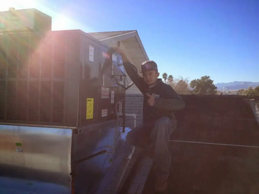 HVAC technician performing Boiler Repair on a rooftop unit in Landen